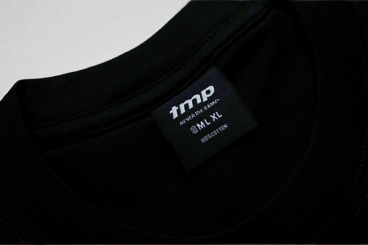 Black t-shirt with a brand label on a light gray background